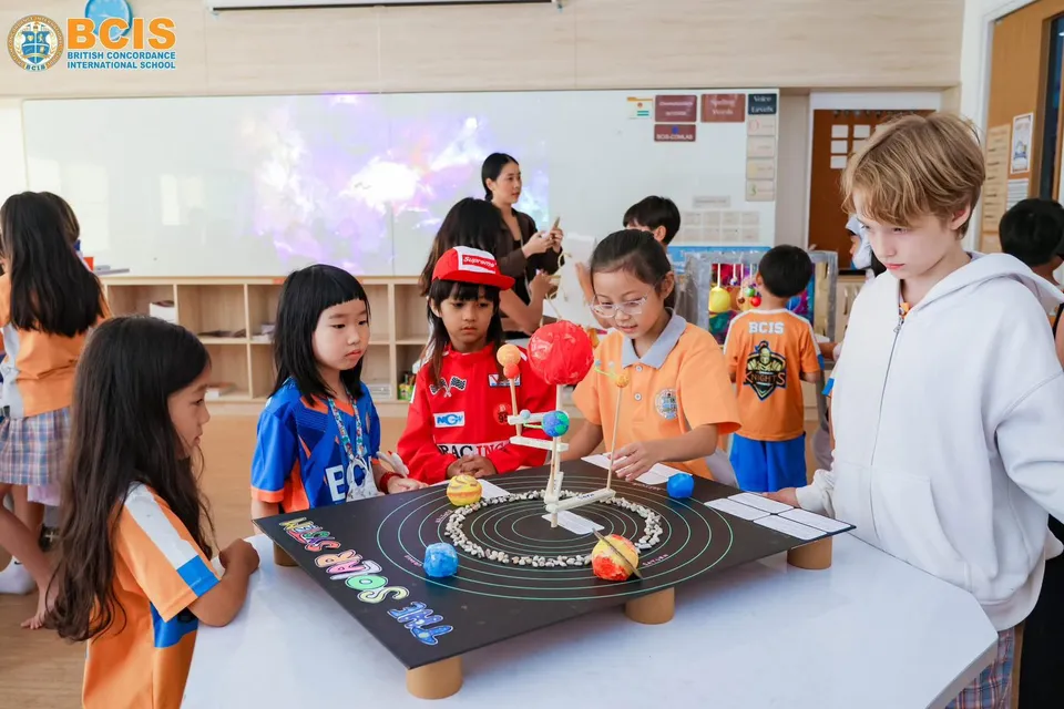 Primary pupils exploring a solar system model together at BCIS