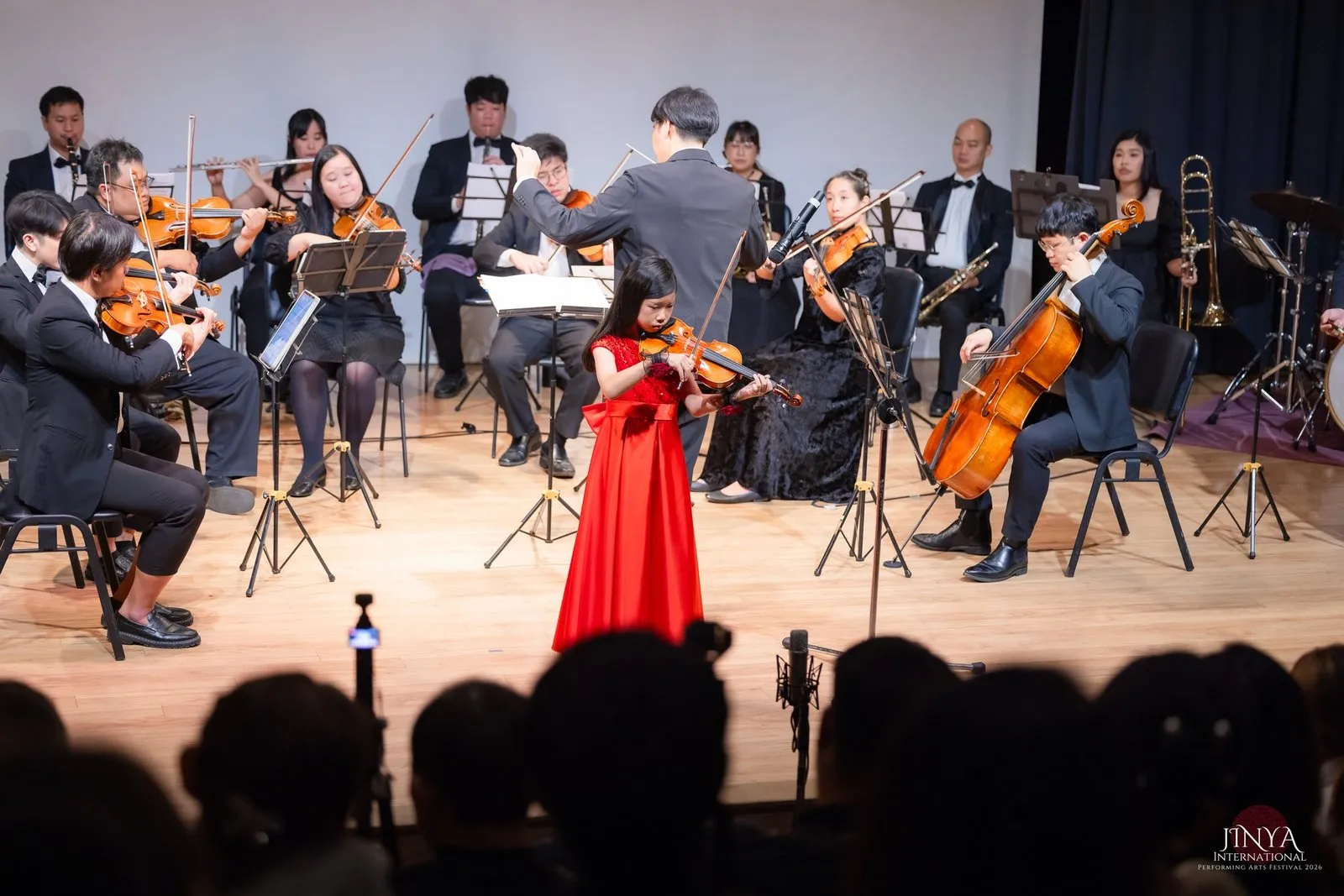 Patricia performing violin with the orchestra in front of the audience