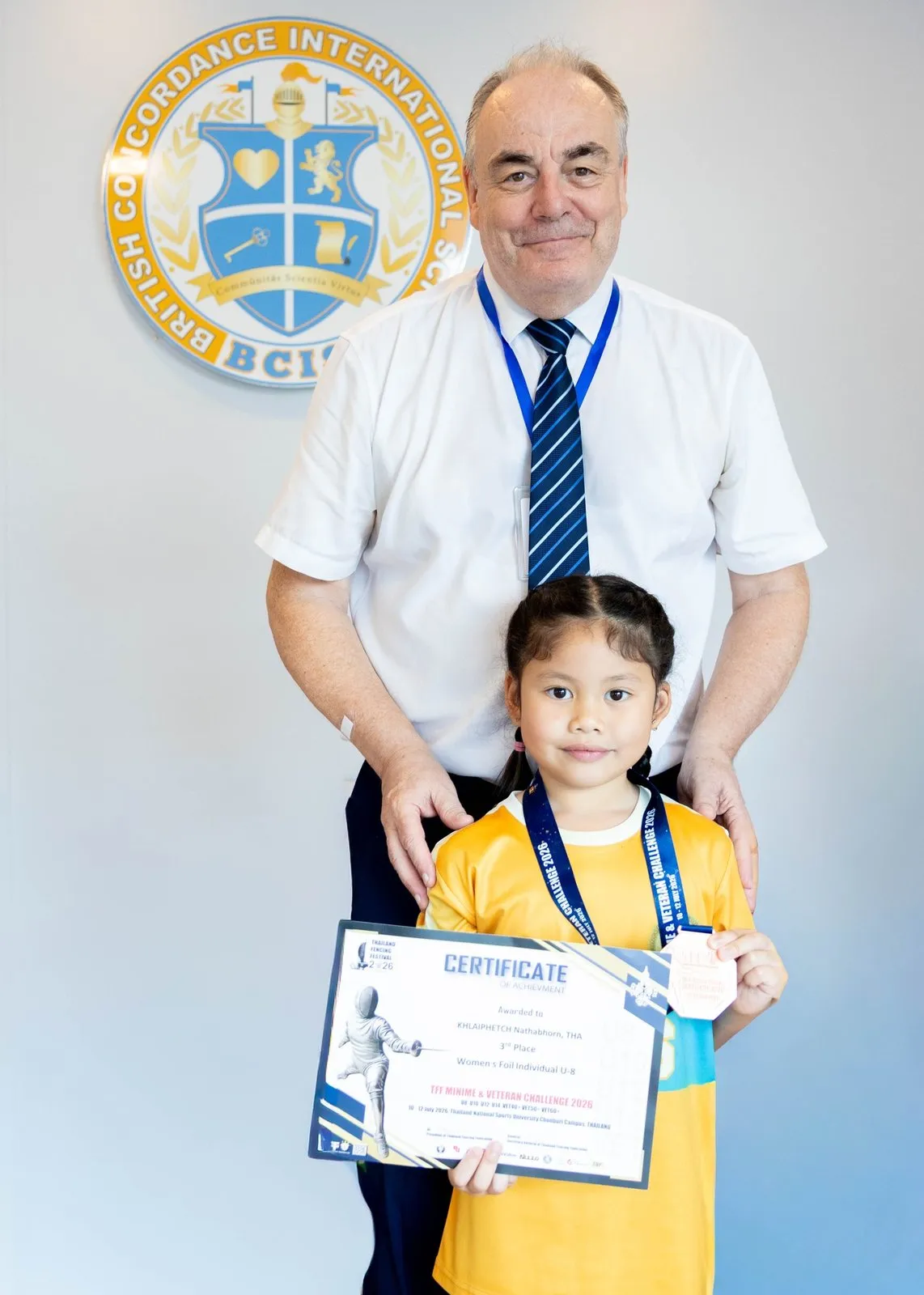 Primprim with her medal and certificate and the Head of School at BCIS