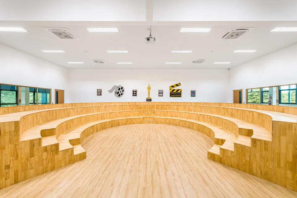 The BCIS music room, with curved tiers of wooden seating around a central floor for performing