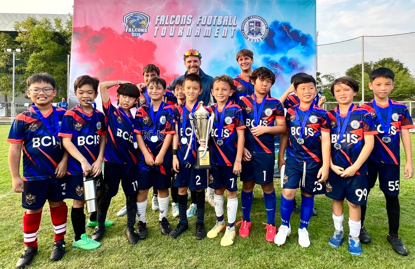 U10 BCIS Knights football team celebrating with the Falcons Football Tournament trophy