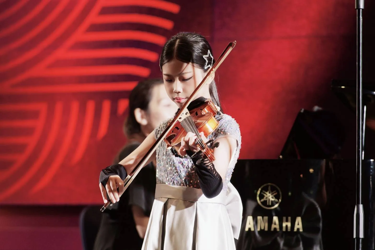 Patricia playing the violin on stage at the JINYA International Performing Arts Festival 2026