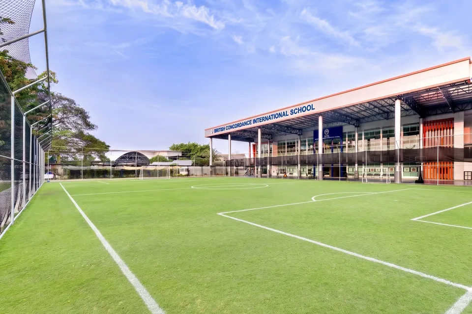 BCIS full-size grass football pitch with the main school building behind