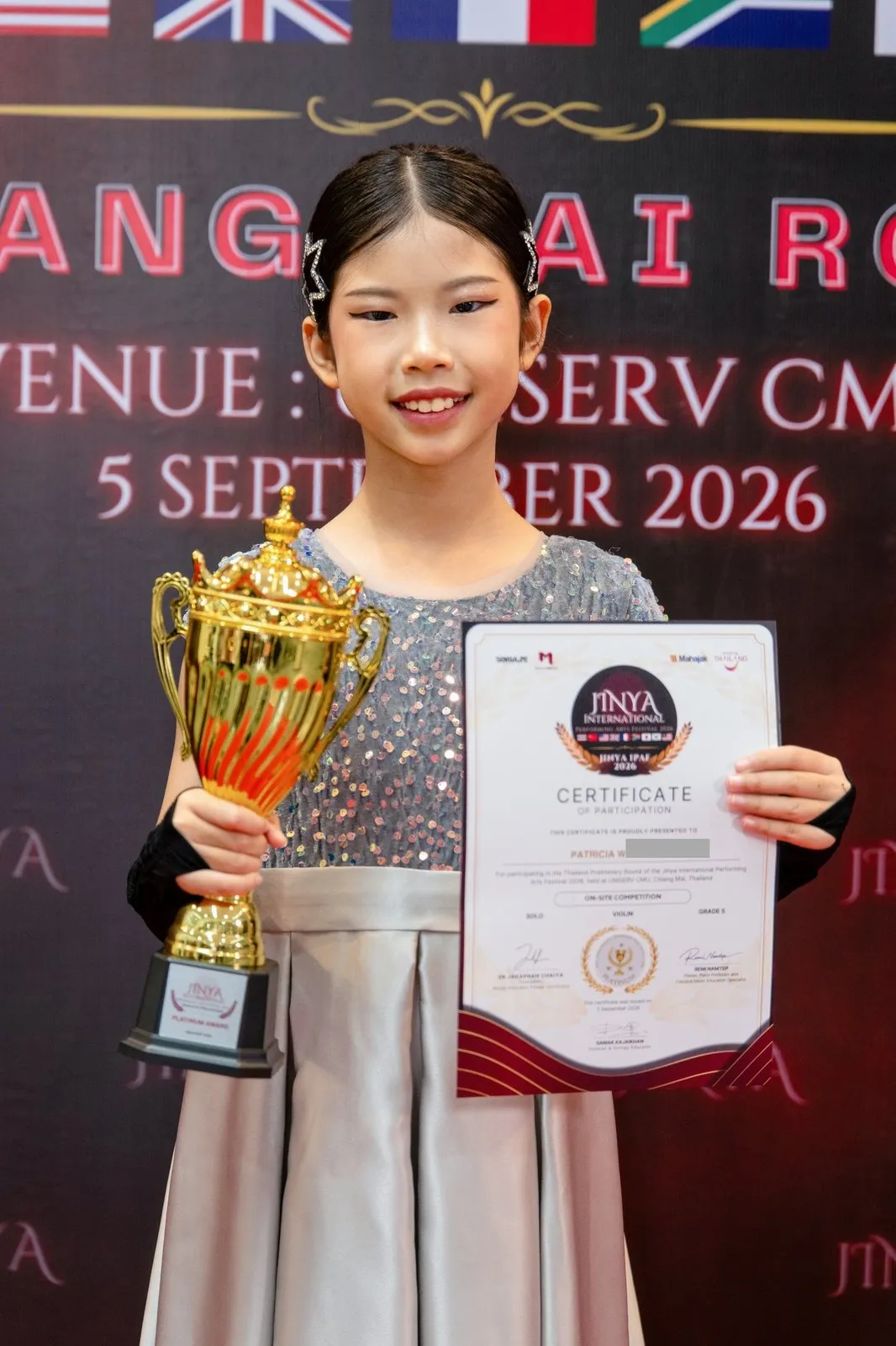 Patricia smiling with her trophy and certificate