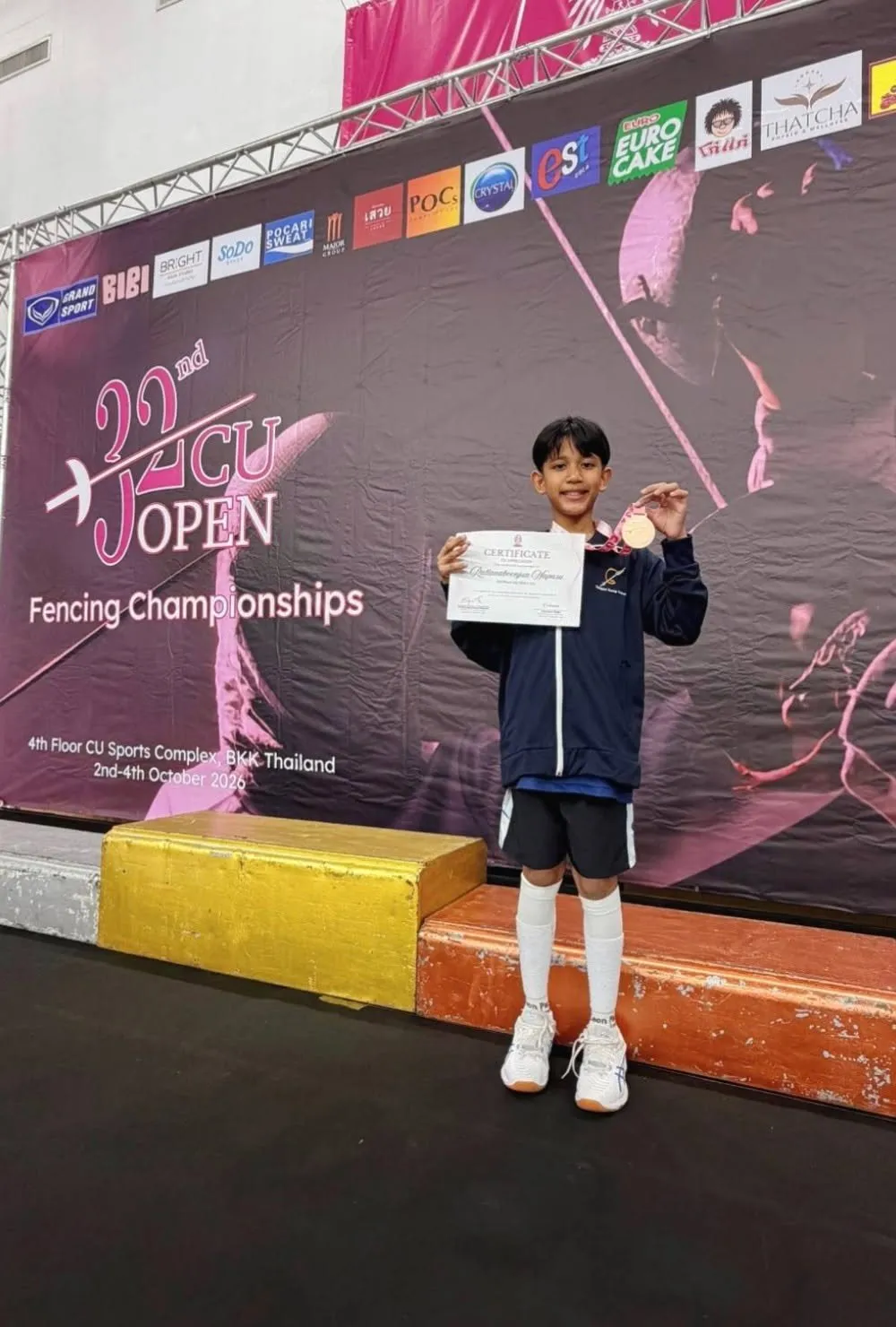 Pluem on the podium with his medal and certificate