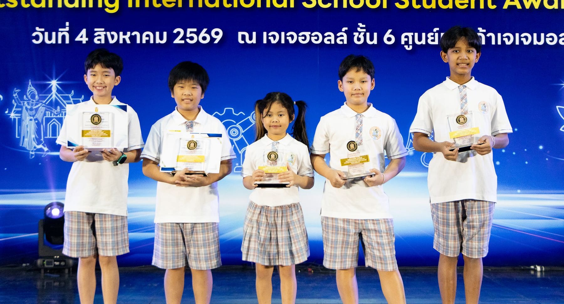 Five BCIS students holding their trophies on stage at the Outstanding International School Student Award 2026 ceremony