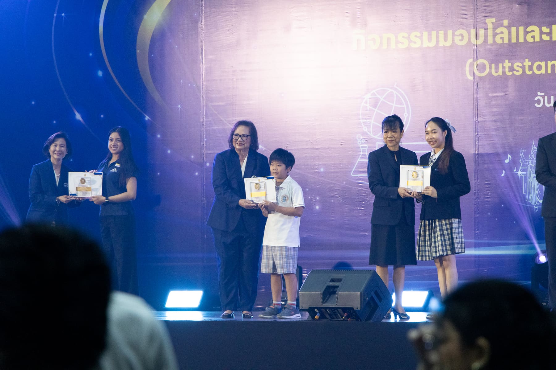 A BCIS student receiving his certificate and trophy on stage