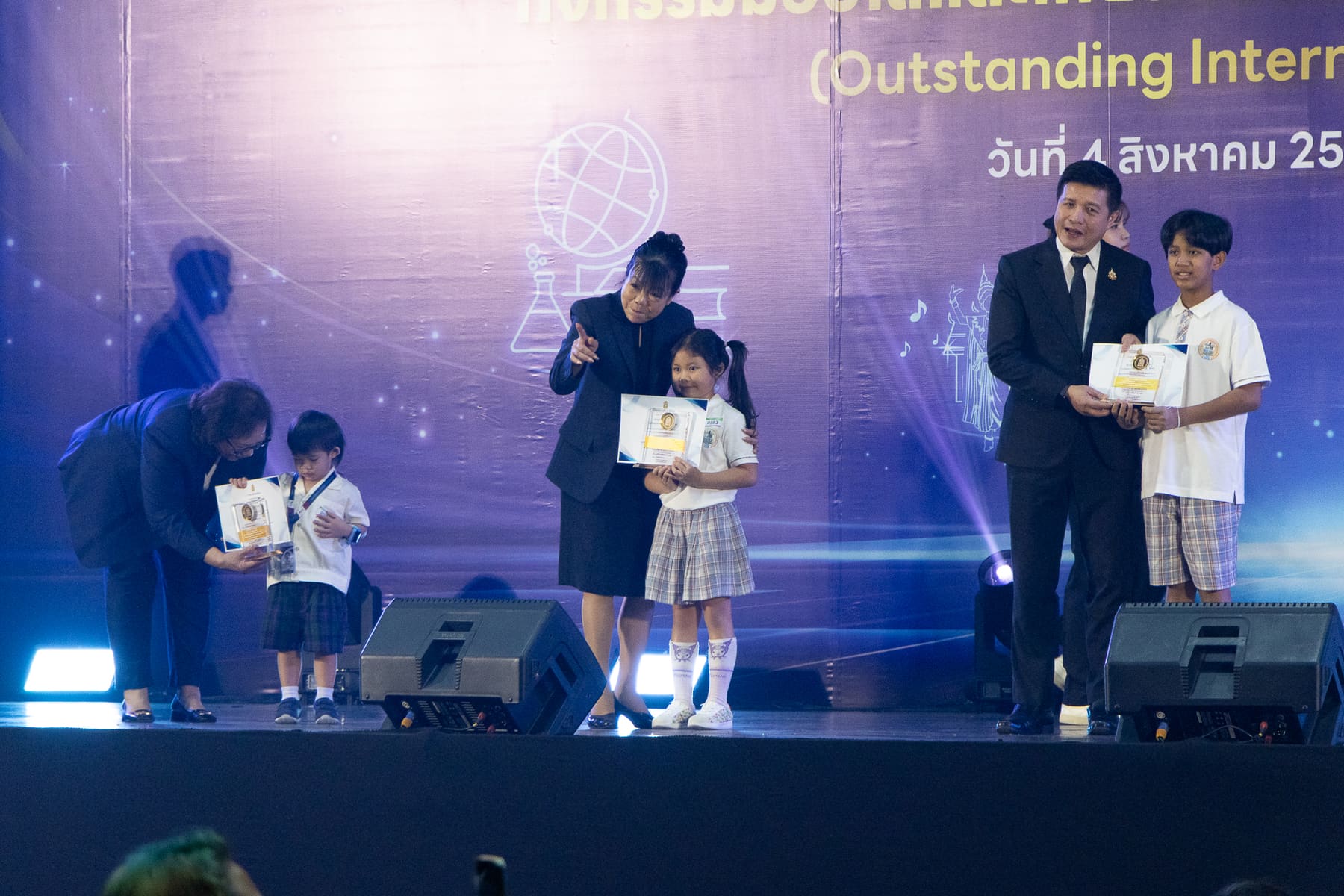 A young BCIS student receiving her award on stage alongside an older recipient
