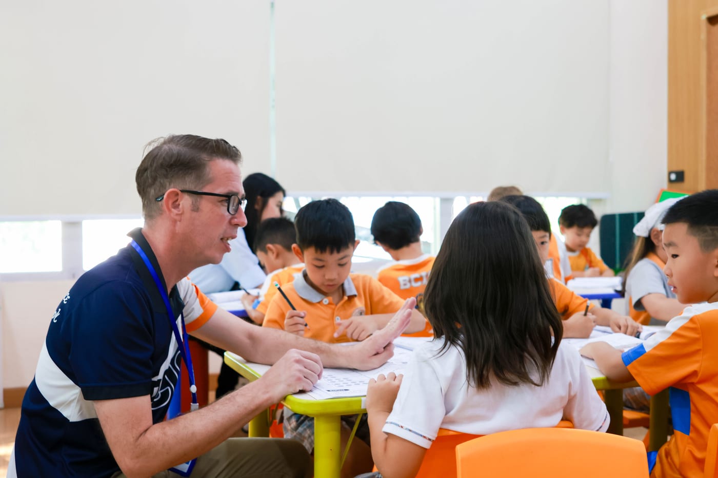 British teacher working one-on-one with Primary students at BCIS