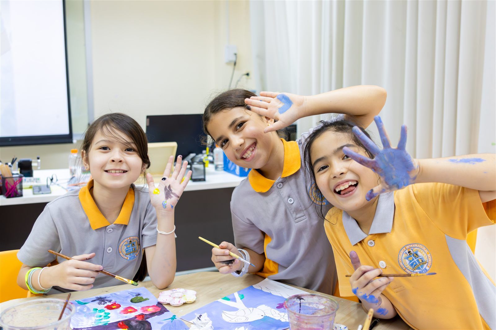 BCIS students with paint on their hands during an art lesson