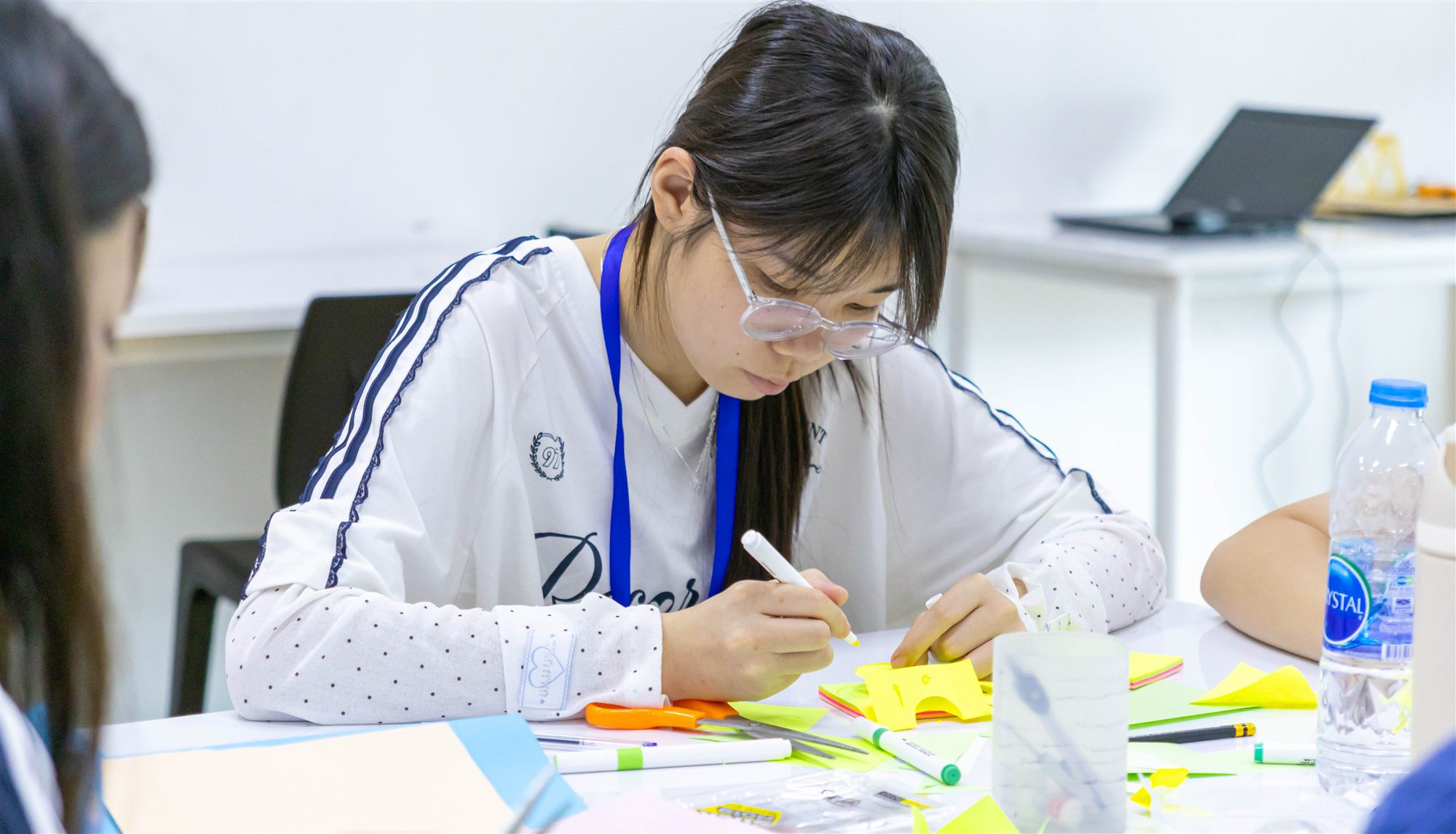 A camper concentrating on a paper craft activity