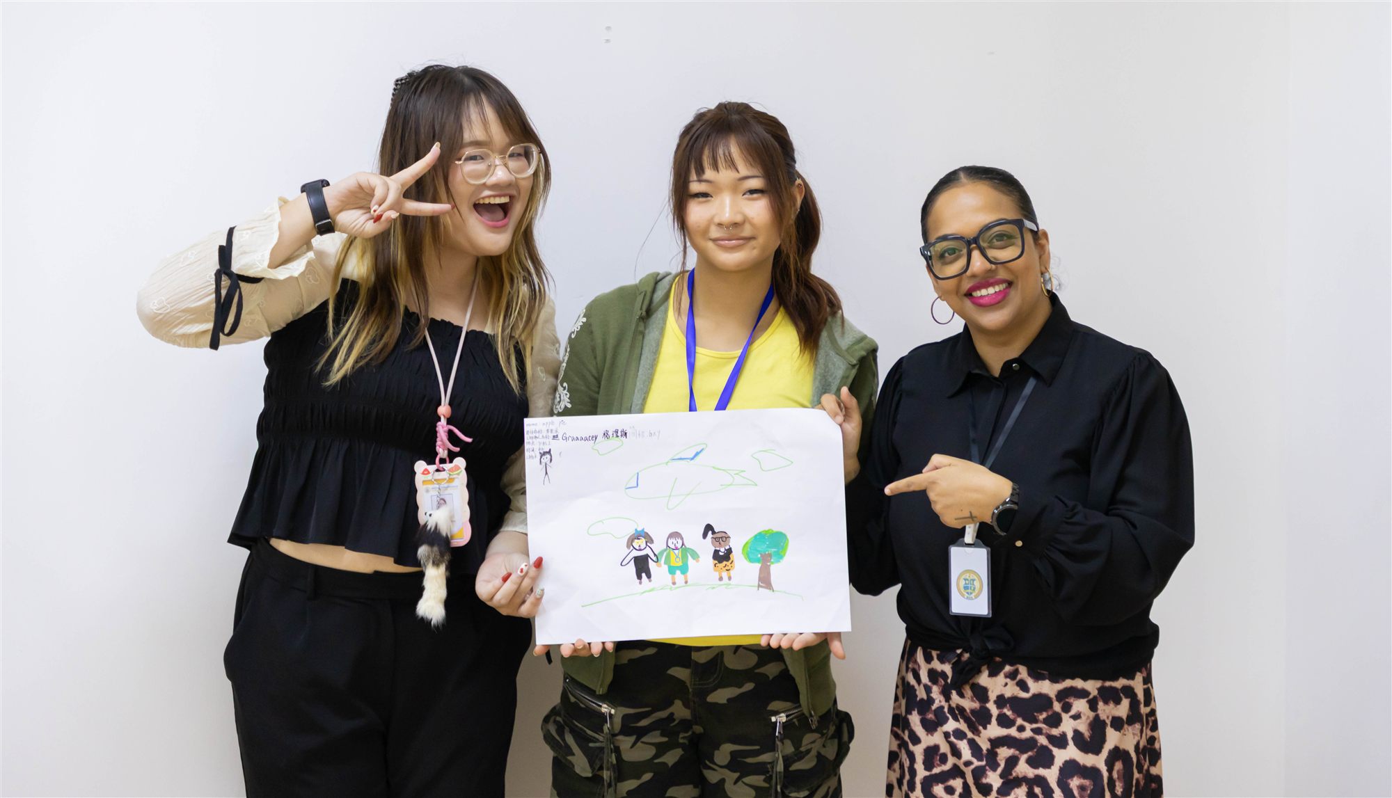 Staff and a camper holding up a finished piece of artwork