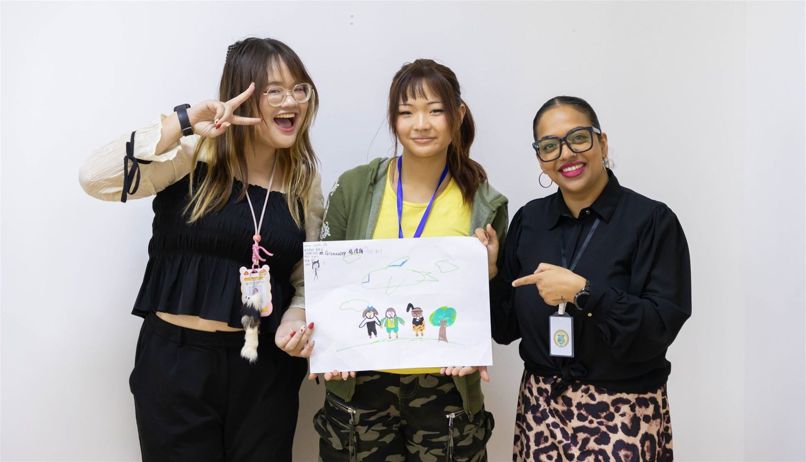 Staff and a camper holding up a finished piece of artwork
