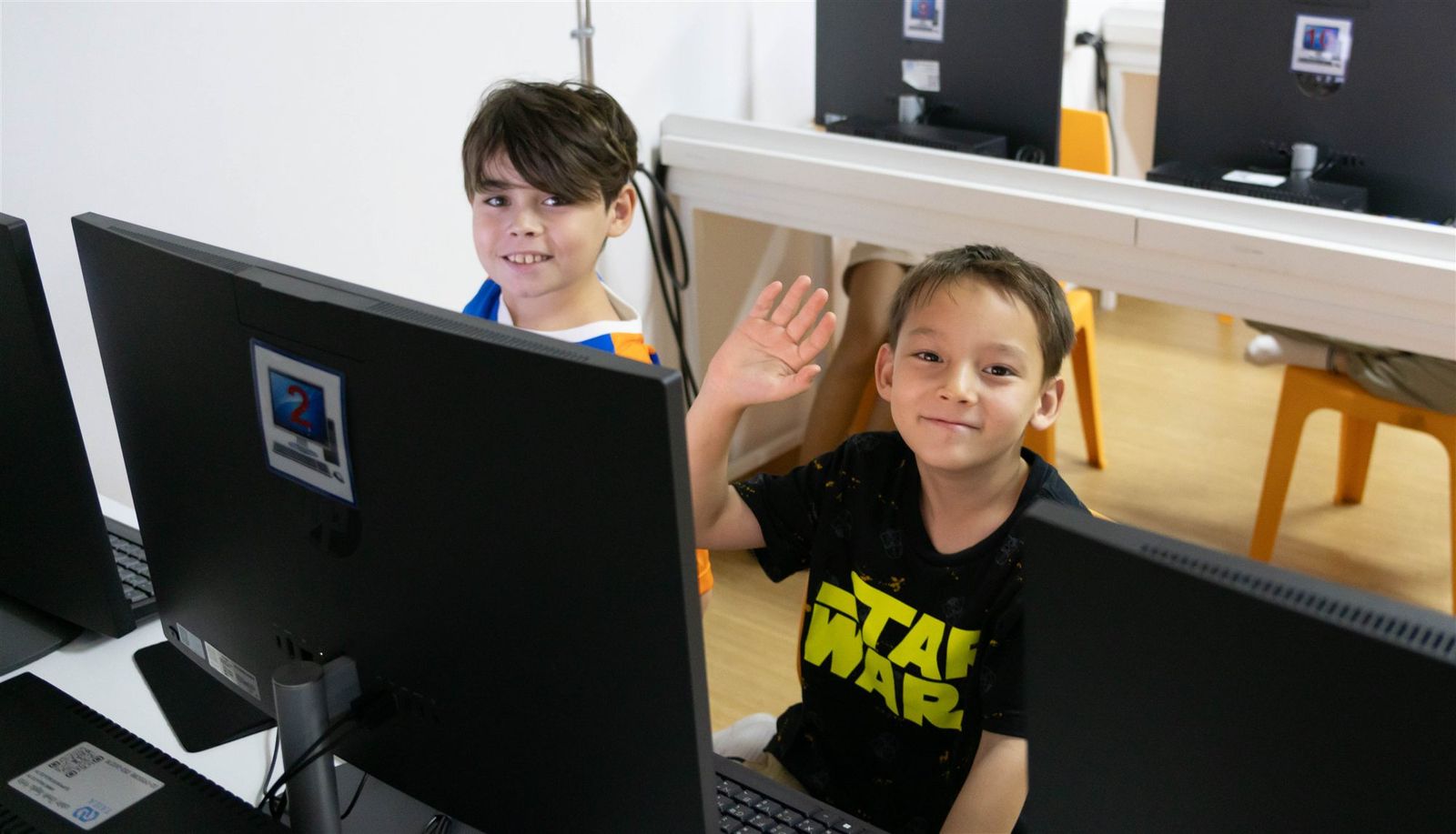 A camper waving hello from the computer lab