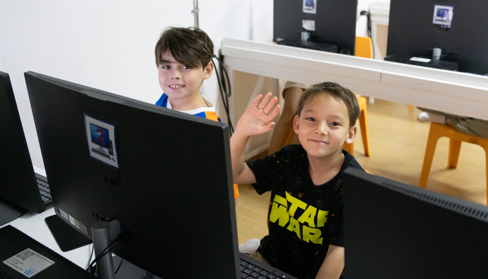 A camper waving hello from the computer lab